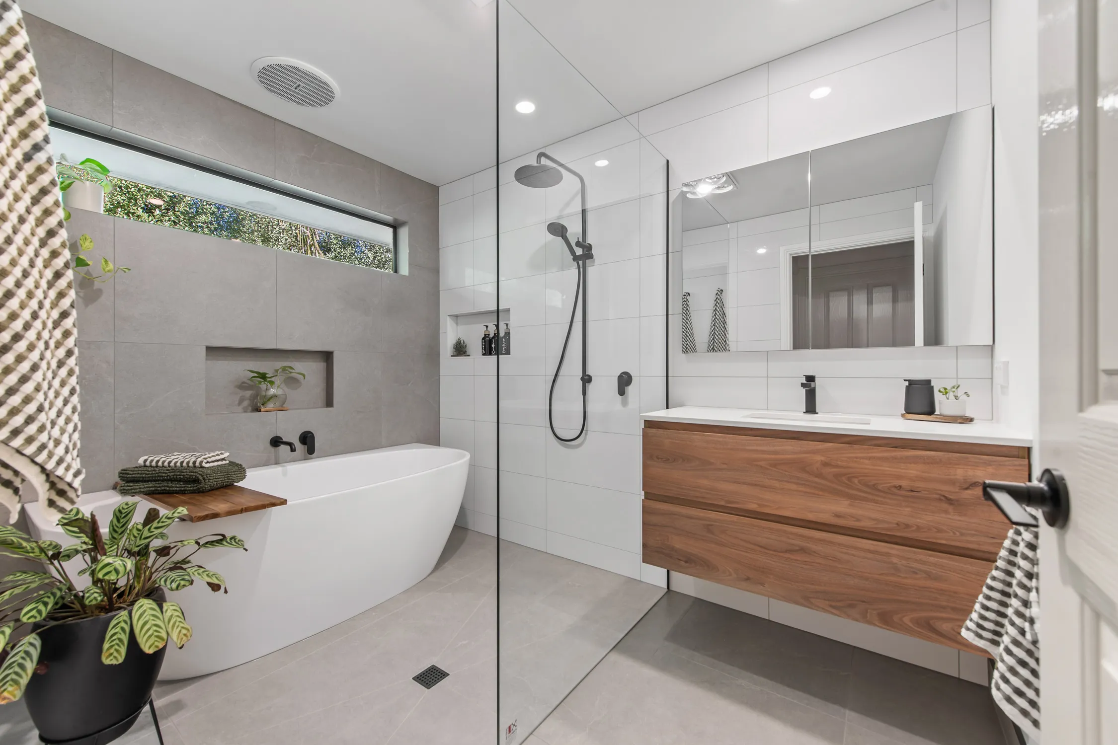 Floating timber-look vanity with matte black mixer and white stone benchtop