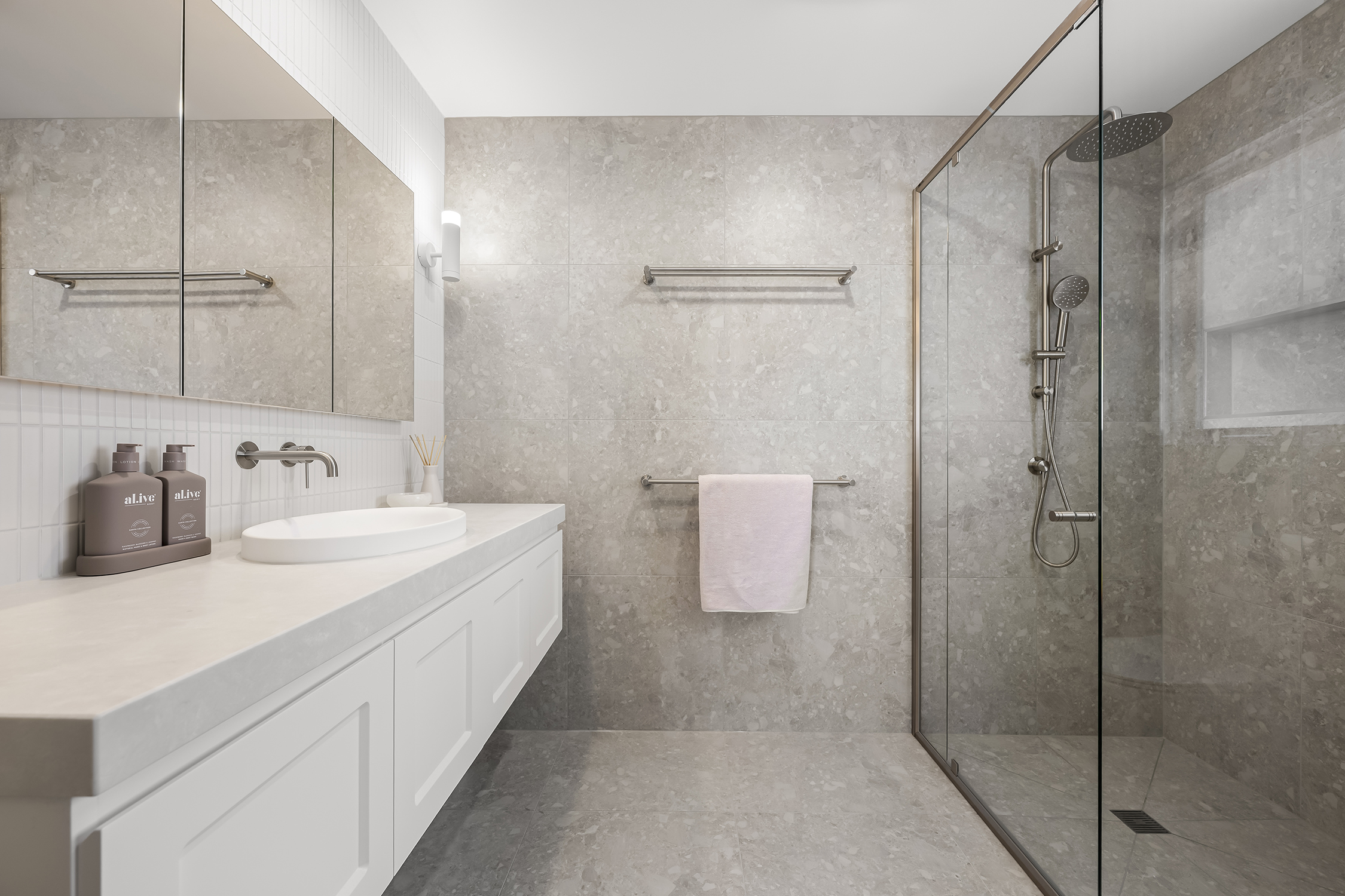 Side view of the stylish bathroom showcasing the contemporary design of the vanity and elegant tile layout.