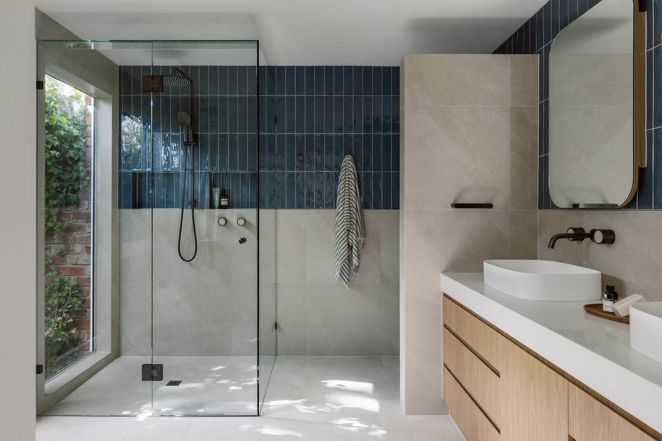 High-end custom vanity with modern basin design and frameless mirror in a contemporary ensuite.