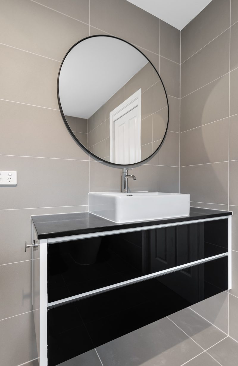 Freestanding bath with black exterior beneath frosted window