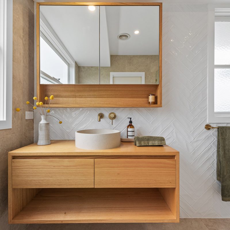 Front view of custom vanity with open shelving and mirror cabinet above.