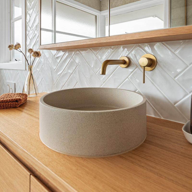 Wide-angle view of ensuite bathroom with floating vanity, textured tiling, and ample natural light.