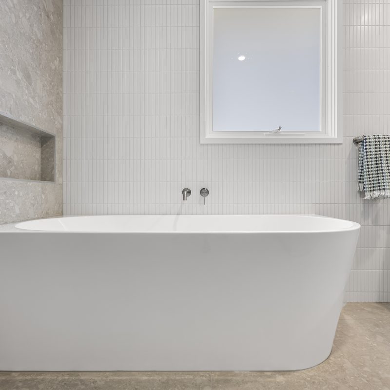 A sleek and functional bathroom design with a custom shaving cabinet, luxury tapware, and elegant wall tiles in a modern aesthetic.