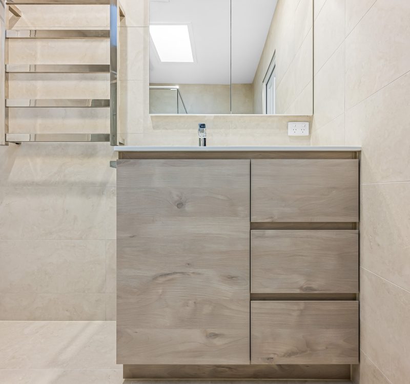 Timber-look floating vanity with mirrored cabinet and towel rail