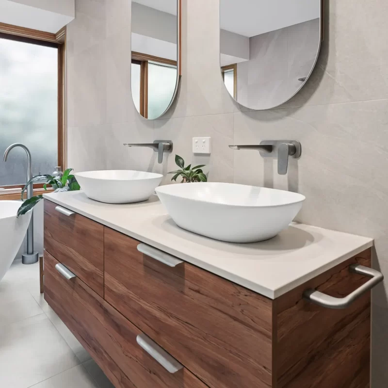 Side view of floating timber vanity with stone benchtop and twin basins in custom bathroom cabinets.